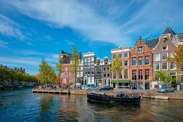 Вид Амстердама - канал с катером, мостом и старыми домами — стоковое фото