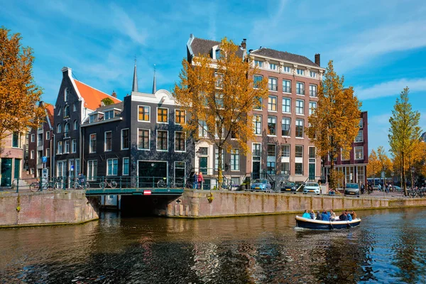 Blick auf Amsterdam - Kanal mit Bootssteg, Brücke und alten Häusern — Stockfoto
