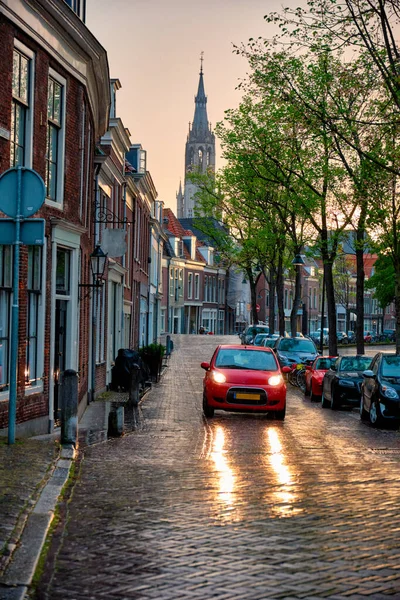 Delft kaldırım taşı caddesi, yağmurda araba. — Stok fotoğraf