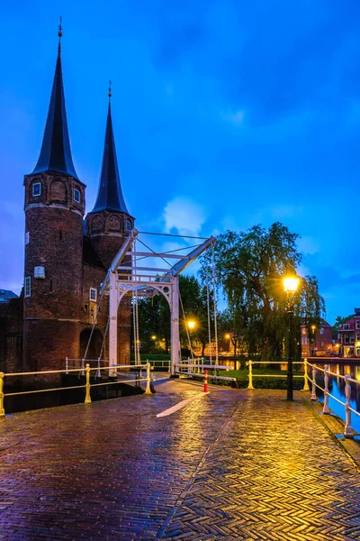 Восточные ворота Остпорта Дельфта ночью. Делфт, Нидерланды — стоковое фото