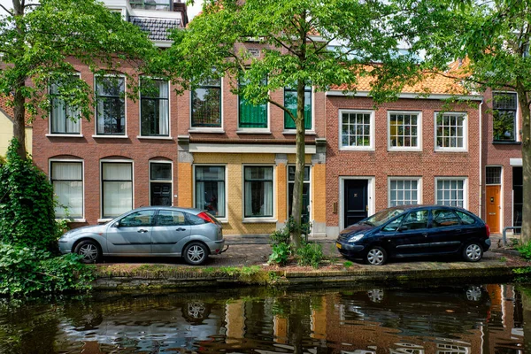 Coches en el terraplén del canal en la calle de Delft. Delft, Países Bajos —  Fotos de Stock