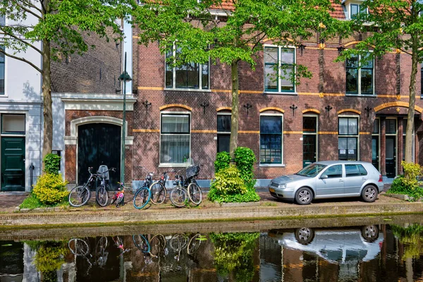 Coches en el terraplén del canal en la calle de Delft. Delft, Países Bajos —  Fotos de Stock