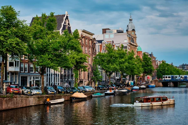 Blick auf Amsterdam - Kanal mit Bootssteg, Brücke und alten Häusern — Stockfoto