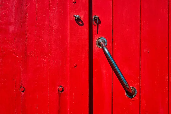 Gammal målad röd trädörr med dörrhandtag — Stockfoto