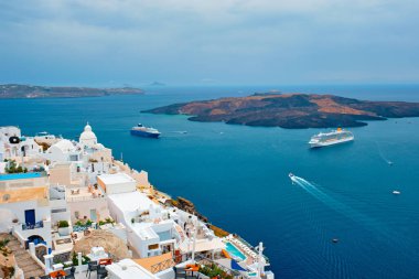 Santorini adasındaki Fira şehrinin manzarası. Denizdeki yolcu gemileriyle.