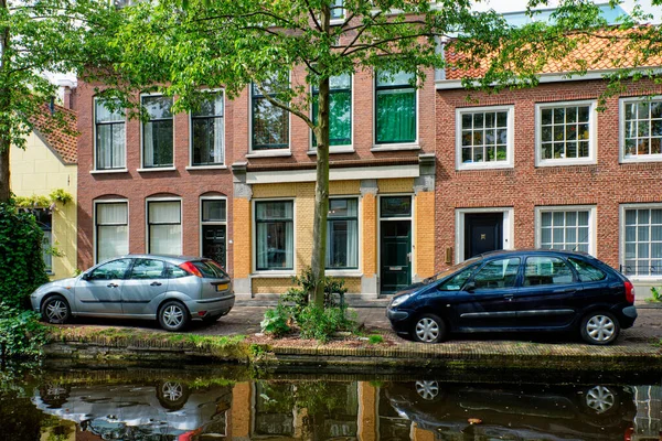 Coches en el terraplén del canal en la calle de Delft. Delft, Países Bajos —  Fotos de Stock
