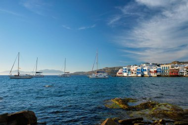 Yunanistan 'ın Mykonos kentinde günbatımı, limanda yolcu gemisi ve yatlarla