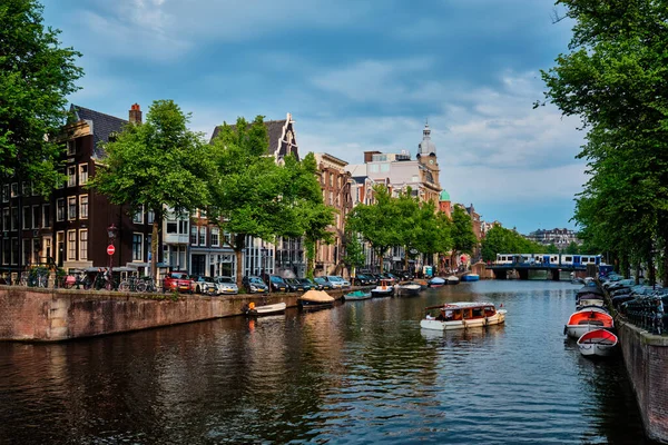 Blick auf Amsterdam - Kanal mit Bootssteg, Brücke und alten Häusern — Stockfoto