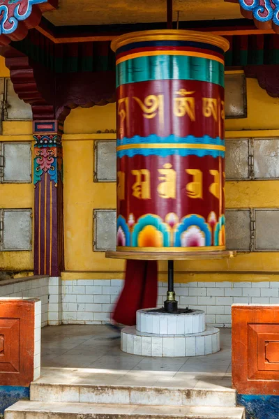 Buddhist monk rotating big prayer wheel — Stock Photo, Image