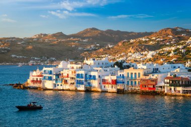 Yunanistan 'ın Mykonos kentinde günbatımı, limanda yolcu gemisi ve yatlarla