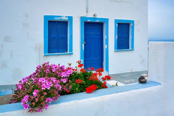 Griechisches weißes Haus mit blauer Tür und Jalousien Oia Dorf auf Santorin Insel in Griechenland — Stockfoto