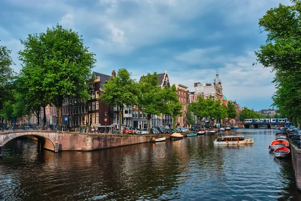 Amsterdam view - kanál s boadem, mostem a starými domy — Stock fotografie