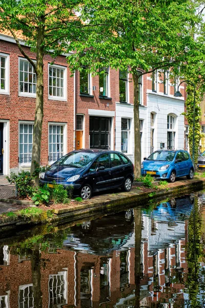 Coches en el terraplén del canal en la calle de Delft. Delft, Países Bajos —  Fotos de Stock