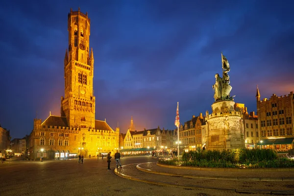 Torre Belfry e praça Grote markt em Bruges, Bélgica ao anoitecer no crepúsculo — Fotografia de Stock