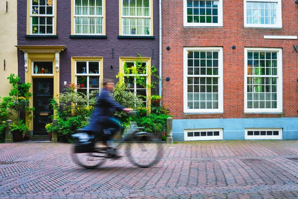 自転車に乗って自転車に乗ってサイクリスト男は、オランダのデルフトの通りでオランダでのトランジットの非常に人気のある手段 — ストック写真