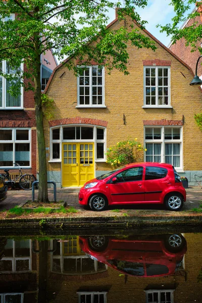 Κόκκινο αυτοκίνητο στο ανάχωμα του καναλιού στην οδό Delft. Delft, Κάτω Χώρες — Φωτογραφία Αρχείου