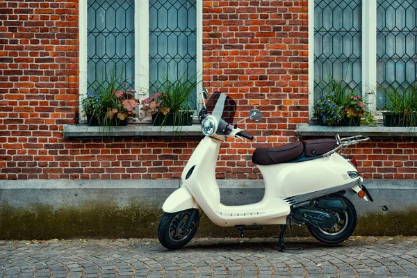 Motor scooter motor geparkeerd nabij de muur van een oud huis — Stockfoto