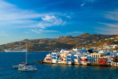 Yunanistan 'ın Mykonos kentinde günbatımı, limanda yolcu gemisi ve yatlarla