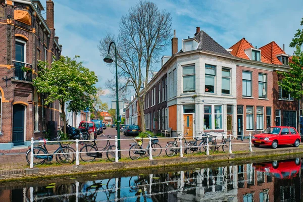 Autók a csatorna töltésénél a Delft utcában. Delft, Hollandia — Stock Fotó