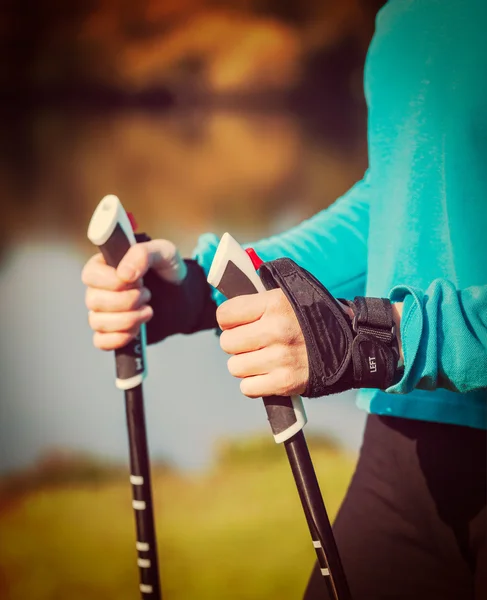 Mão das mulheres segurando pólos de caminhada nórdicos — Fotografia de Stock
