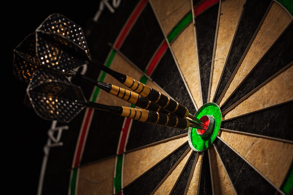 Three darts in bulls eye close up
