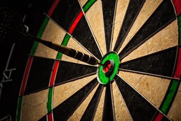 Dart in bulls eye close up — Stock Photo, Image