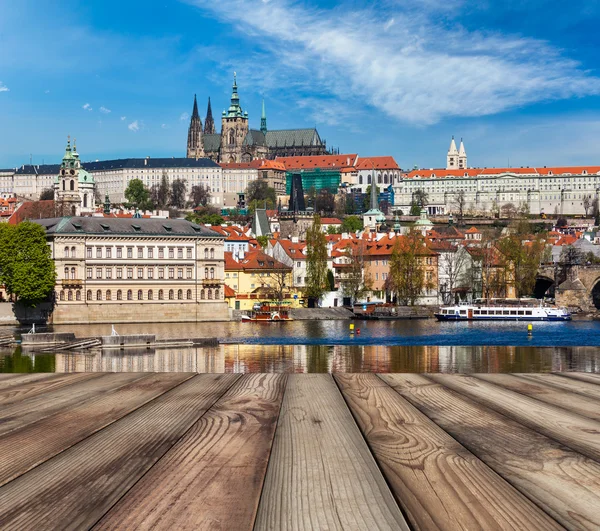 Tablones de madera vith vista del puente de Praga Charles sobre el río Moldava — Foto de Stock