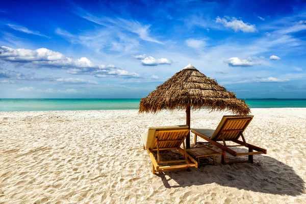 Dos sillas de salón bajo tienda en la playa — Foto de Stock