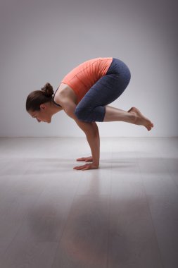 Beautiful sporty fit yogini woman practices yoga asana kakasana
