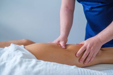 Bir terapist spa salonunda rahatlatıcı bir bacak ve kalça masajı yapar. Odak noktamız rahatlama ve sağlık hizmetleri..