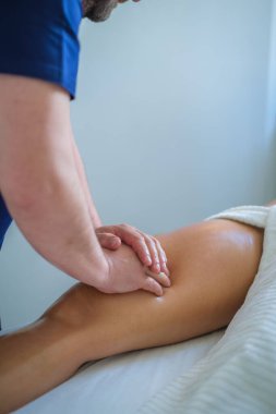 Yetenekli bir terapist, huzur verici bir spa ortamında yağ, rahatlama ve sağIığı kullanarak rahatlatıcı bir bacak ve but masajı yapar..