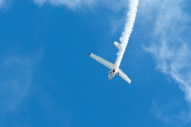 Dublör akrobatik uçak dumanla mavi gökyüzünde gösteri yapıyor. Hız kavramı, zorluk, kesinlik, risk, meydan okuma