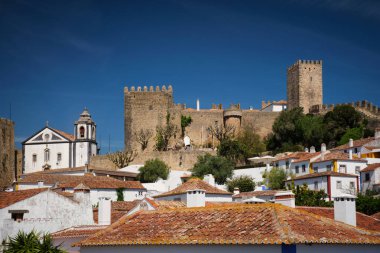Obidos 'un ortaçağ şatosunu ve açık mavi gökyüzünün altındaki beyaz evleri keşfedin. Portekiz' in tarihine büyüleyici bir bakış..