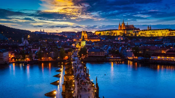 Vista nocturna del castillo de Praga y el puente de Carlos sobre el río Moldava Fotos De Stock