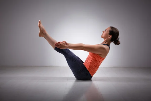 Woman practices yoga asana Paripurna navasana — Stock Photo, Image