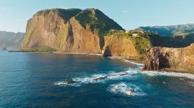 Madeira kayalıkları kıyı şeridi manzarası gündoğumunda, Guindaste bakış açısı, Madeira Adası, Portekiz. Geri çekilin. Doli atış.