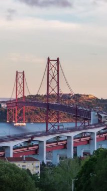 Lizbon 'un Miradouro do Bairro do Alvito turist bakış açısından Tagus nehrine bakması, 25 Nisan Köprüsü trafiği ve günbatımında Kral İsa heykeli. Lizbon, Portekiz. Etkin büyüt