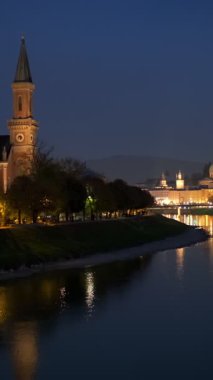 Salzburg gece manzaralı. Katedral, Altstadt Eski Kasabası, kilise, Hohensalzburg, şato ışıklarla aydınlatılmış. Salzach Nehri kıyısı ve gezinti güvertesi. Salzburg, Avusturya