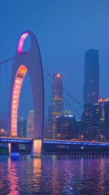 Guangzhou 'nun Zhujiang İnci Nehri üzerindeki Liede Köprüsü manzarası ve geceleri aydınlanan finansal bölgenin modern gökdelenleri. Guangzhou, Çin