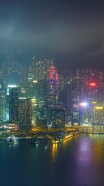 Aydınlatılmış Hong Kong gökdelenlerinin hava zaman çizelgesi şehir merkezindeki gökdelenlerin akşamları. Hong Kong, Çin. Uzaklaştırma efekti