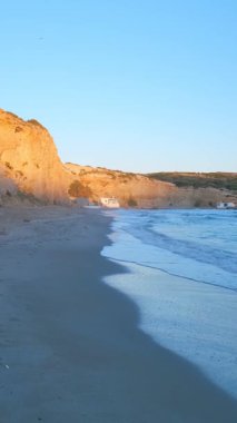 Fyriplaka sahilindeki kayaların yanında yürümek ve gün batımında Ege Denizi 'nin dalgaları, Milos Adası, Kiklad, Yunanistan. Sabit kamera görüntüsü