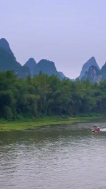 Li Nehri 'ndeki turist teknelerinin arkasında dramatik bir karst dağı manzarası var. Yangshuo, Çin. Yatay kamera tavası