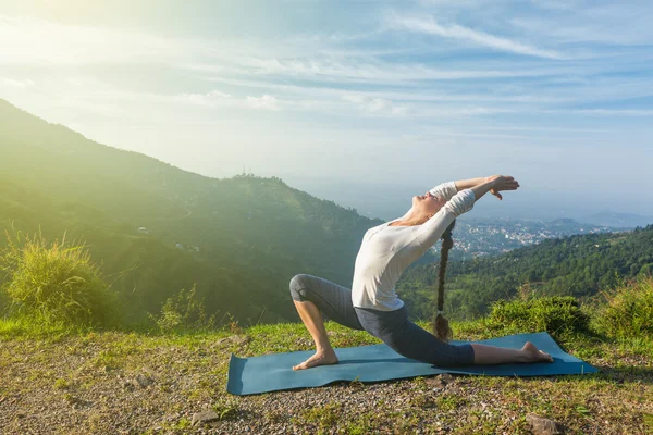 Vrouw doet yoga asana Anjaneyasana in Bergen — Stockfoto