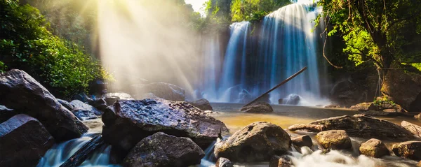 Tropické vodopád v džungli s paprsky slunce — Stock fotografie