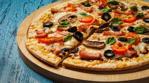 Schinken-Pizza auf blauem Holzgrund — Stockfoto