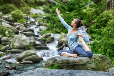 Sorty fit woman doing yoga asana outdoors