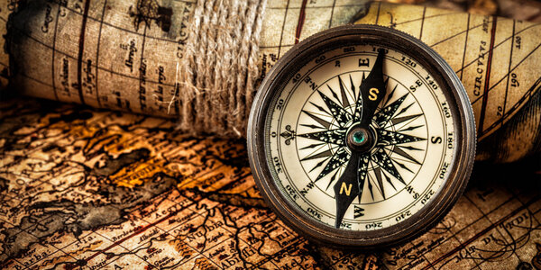 Old vintage compass on ancient map