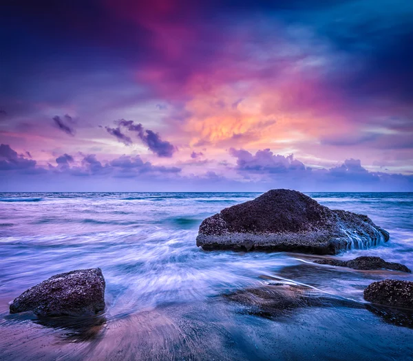 Ondas e rochas na praia de pôr do sol — Fotografia de Stock