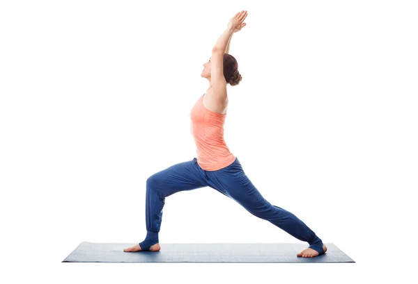 Vrouw praktijken yoga Warrior asana — Stockfoto
