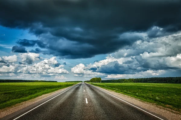 Yol ve fırtınalı gökyüzü — Stok fotoğraf